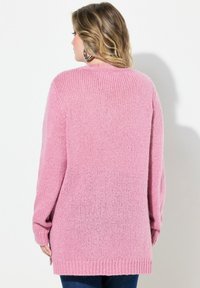 Różowy sweter z dzianiny o luźnym kroju, z długimi rękawami i ściągaczami, z teksturowanym wzorem i okrągłym dekoltem.