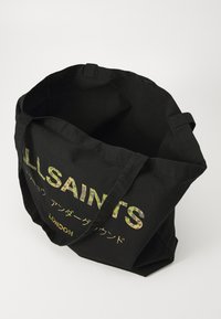 Juodas drobės tote krepšys su dviem rankenomis, puikuojantis "ALLSAINTS" logotipu kamuflažo raštu. Atviras viršus, leidžiantis lengvai prieiti.