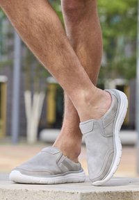 Gray slip-on shoes made of suede with elastic side panels and a white rubber sole. The design features subtle stitching and accents.