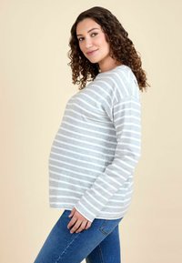 Baba-mama póló hosszú ujjakkal, szürke és fehér vízszintes csíkokkal, laza szabással, lekerekített alsó résszel, puha pamut keverék anyagból.