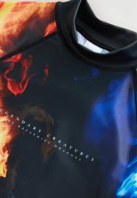 Rash guard i lätt, elastisk material med en svart bas och livfulla, eldiga orange och blå swirl-mönster, plus vit textdesign.
