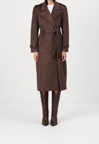 Brąszowy długi płaszcz trench w miękkim, przypominającym zamsz materiał, z podwójnym zapięciem, paskiem w talii oraz szczegółowymi guzikami.