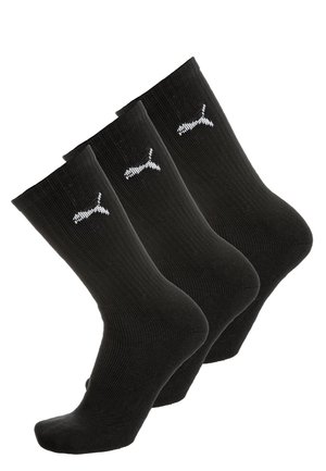 Tres pares de calcetines negros de caña corta con el logotipo blanco de Puma en el tobillo, exhibidos en una disposición escalonada.