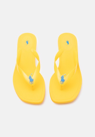 Tongs jaunes avec des brides translucides, chacune ornée d'un logo de joueur de polo bleu sur la semelle et la bride, affichées côte à côte.
