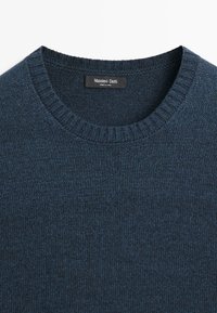 Maglione a maglia blu navy con scollo rotondo e bordi a coste. L'etichetta riporta "Massimo Dutti, Made in China."