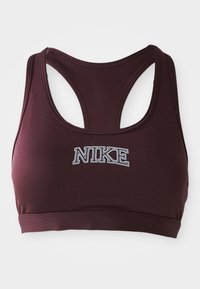 Tumši bordo Nike sporta krūšturis ar racerback dizainu un baltu kontūrētu "NIKE" tekstu centrā uz priekšpuses.