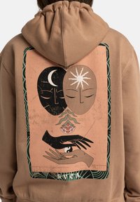 Brun hoodie med snodd i huvan och ett grafiskt tryck på baksidan som föreställer två abstrakta ansikten, en hand och botaniska element.
