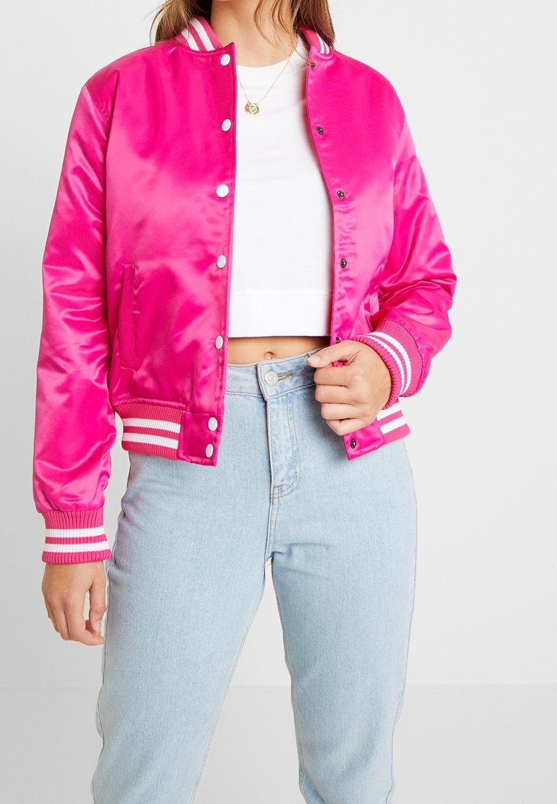 Bright pink satin bomber jacket with white and pink striped ribbed cuffs and collar, featuring snap buttons and a relaxed fit.