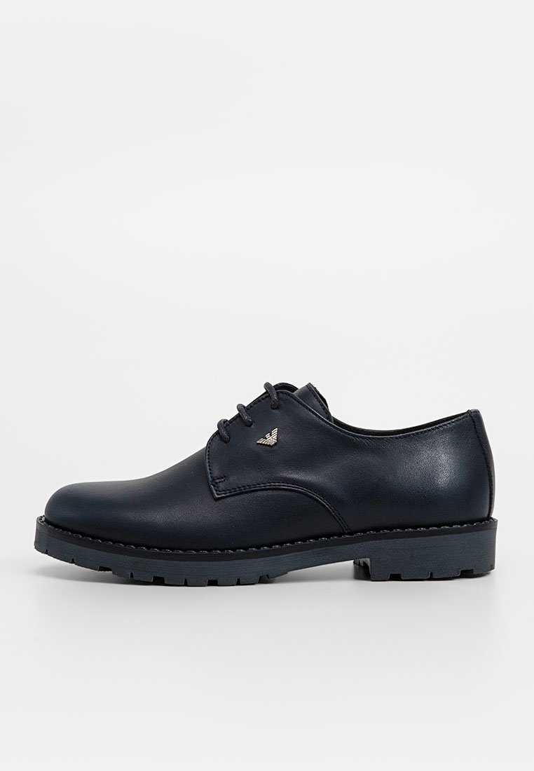 Scarpa oxford in pelle nera con finitura liscia, punta tonda e design con lacci. Presenta una suola testurizzata a contrasto e un piccolo logo argentato.