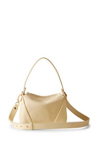 Beige leather handbag with a curved, soft shape. Features a single handle and a detachable strap with gold hardware accents.