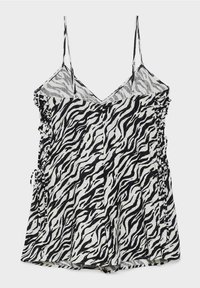 Combinaison sans manches à imprimé zèbre noir et blanc avec des bretelles spaghetti ajustables et des détails de cordon latéral.