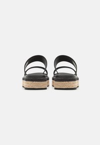 Sandali platform neri in pelle con due cinturini arrotondati, dotati di una suola intermedia in juta intrecciata e di una suola in gomma testurizzata. Design con tacco piatto.