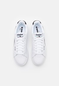 Sneaker bianchi in pelle con accenti neri, punta rotonda, lacci piatti e dettaglio perforato sui lati. Marchio sulla linguetta.