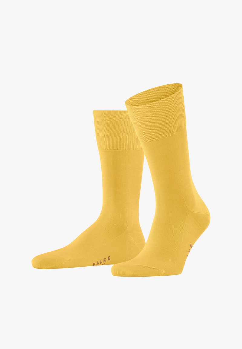 Paire de chaussettes jaunes vives longueur mollet avec bord-côtes et logo "FALKE" près des orteils, présentées sur un fond blanc.