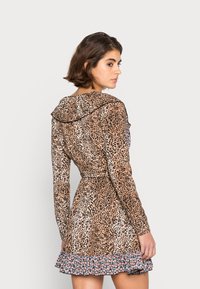 Vestido de estampa de leopardo com mangas longas, decote franzido, cintura ajustada e uma renda floral na bainha. Feito de tecido leve.