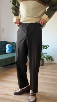 Μαύρο, ραμμένο παντελόνι με λεία υφή και πιέτες μπροστά, συνδυασμένο με καφέ μοκασίνια που έχουν αντίθετη λευκή λεπτομέρεια.