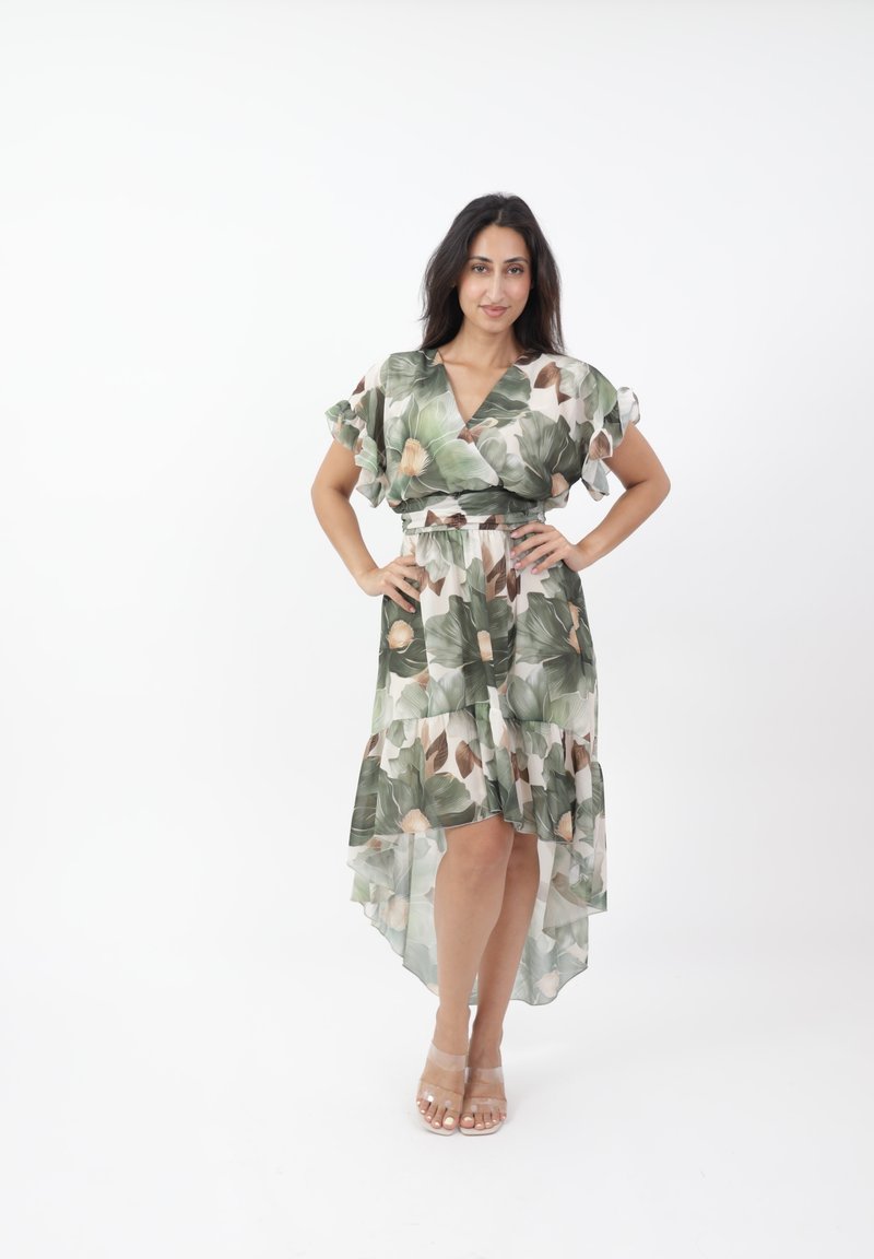 Abito floreale con motivi di foglie verdi, maniche corte e orlo asimmetrico. Realizzato in tessuto leggero con una vestibilità rilassata. Tacchi trasparenti inclusi.