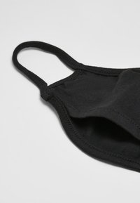 Svart tygmask med elastiska öronloopar, mjuk textur, böjd design och dubbelskiktad konstruktion för förbättrat skydd.