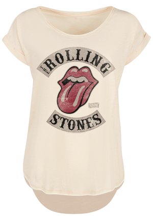 Cream T-shirt with rolled sleeves featuring a distressed red tongue logo and "The Rolling Stones" text in black, loose fit design.