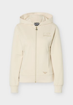 Sudadera con capucha de color crema, con cremallera, mangas largas, bolsillos frontales y sutiles detalles del logo EA7 Emporio Armani en el pecho y el dobladillo.