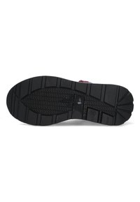 Black rubber shoe sole with a textured grip pattern, featuring ridges and grooves for traction. Reinforced heel and toe sections.