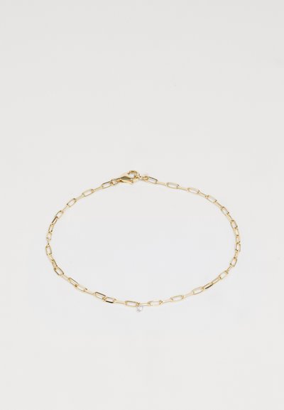 Gouden schakelarmband met verlengde paperclip-stijl schakels, voorzien van een kleine heldere edelsteenaccent en een karabijnsluiting.