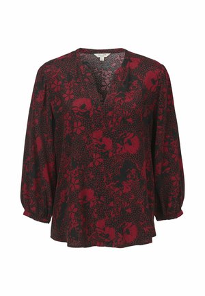 Schwarze Bluse mit einem tiefen V-Ausschnitt, verziert mit einem roten Blumenmuster, langen puffärmeln und einer lockeren Passform. Strukturierter Stoff mit einem gepunkteten Hintergrund.