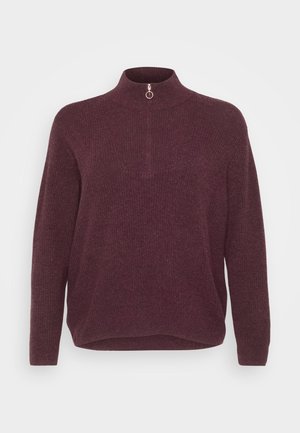 Burgundijas adīta džemperis ar augstu apkakli un īsu rāvējslēdzēju ar apaļu vilkšanas elementu. Brīvs piegriezums ar ribbed tekstūru un garām piedurknēm.