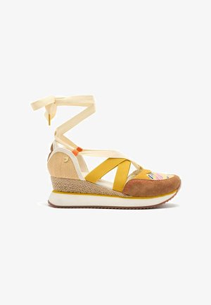 Zapatilla wedge con punta de ante marrón, acentos amarillos, lateral de yute tejido, correas de tela y suela de goma blanca con textura.