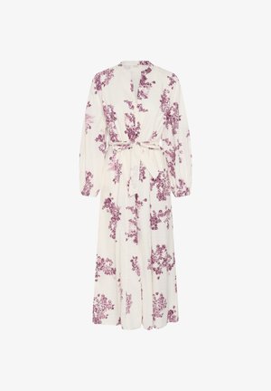 Pikad varrukad, pahkluu pikkune valge kleit lilla lillemustritega, sügava V-kaelusega ja vööd ümber seotud vööga.