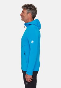 Niebieska bluza z kapturem wykonana z elastycznego materiału, z kieszenią na suwak z przodu, regulowanym kapturem i logo na lewym rękawie. Gładka faktura.