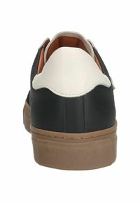 Black and white sneaker with a textured tan rubber sole, rounded shape, and a low-top design featuring a scalloped edge on the heel.