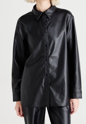 Schwarze Kunstleder-Hemdenjacke mit einem Kragen, durchgehender Knopfleiste, langen Ärmeln und glatter, glänzender Textur.