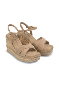 Sandales à talon compensé beiges avec une tige en suède, des brides réglables et des détails en jute tressé sur le talon compensé, présentant une surface texturée.