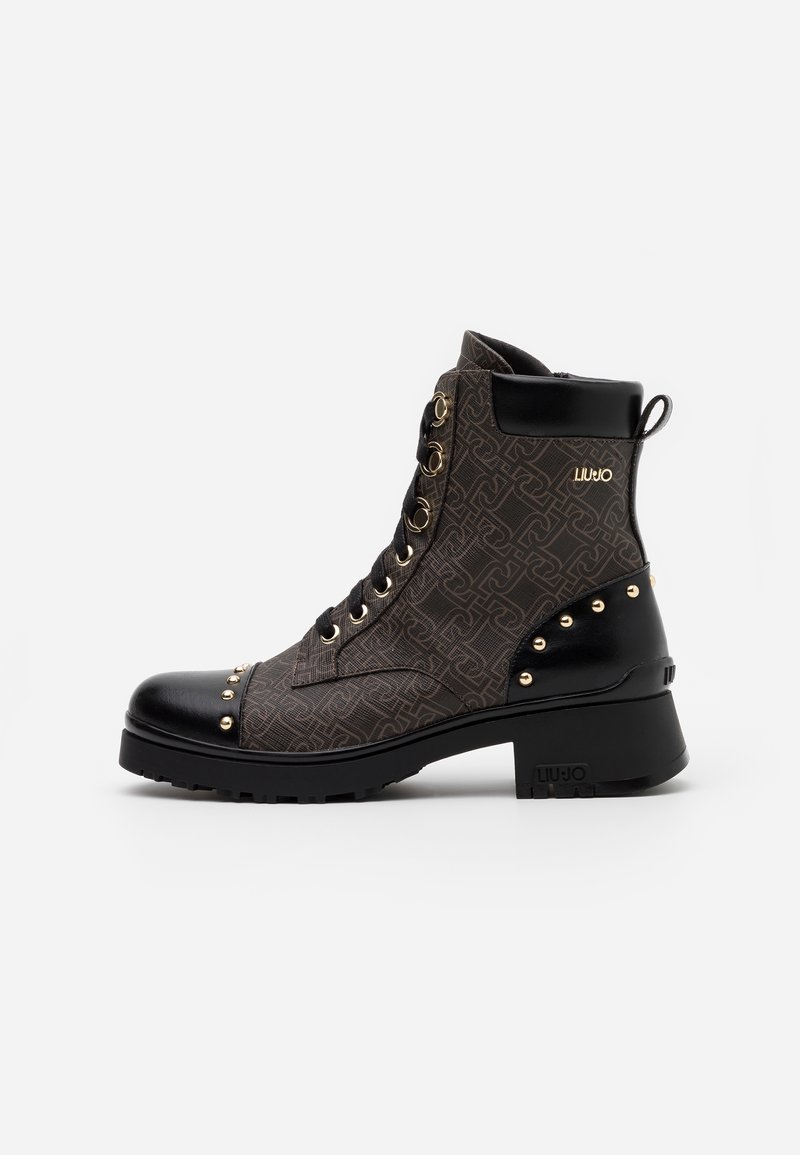 Bottes montantes brun foncé et noires avec tissu à motifs, clous dorés sur le bout et le talon, lacets à l'avant et talon bloc.