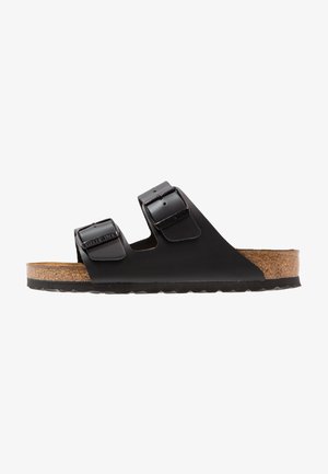 Black two-strap sandal with a cork footbed, featuring smooth synthetic straps and adjustable buckles, textured rubber outsole.