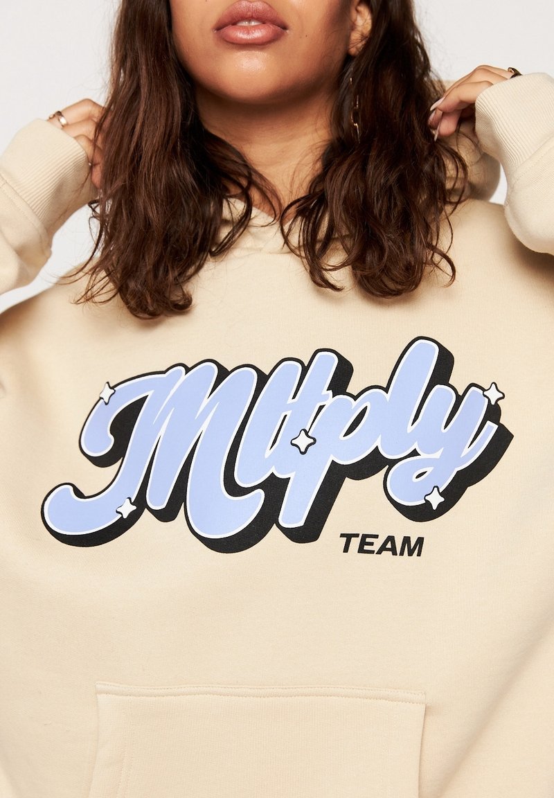 Beżowa bluza z kapturem z dużą, stylizowaną grafiką "Mltply" w kolorze niebieskim i czarnym. Teksturowany materiał z przednią kieszenią i kapturem ze sznurkiem.
