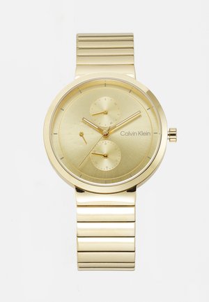 Montre dorée avec un cadran rond, un cadran en or texturé, trois sous-cadrans et un bracelet à maillons. Présente des indices horaires minimalistes et un logo.