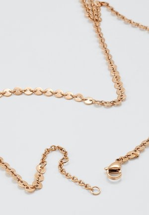 Delikatny naszyjnik z cienkiego złotego łańcuszka z okrągłymi płaskimi ogniwami, zapięciem typu karabińczyk i regulowanym przedłużeniem na jednolitym białym tle.