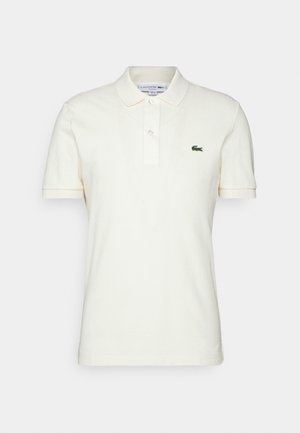 Polo en coton blanc cassé avec manches courtes, col classique, patte de boutonnage à trois boutons et logo crocodile brodé vert sur la poitrine.