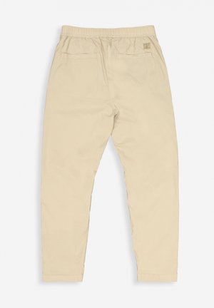 Beige cotton trousers with an elastic waistband, two back pockets, and a slim fit. Features a small brand label on the waistband.