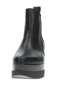 Stivale alla caviglia in pelle nera con finitura liscia, pannelli laterali elastici e suola in gomma spessa e scanalata. Design leggermente rialzato della piattaforma.