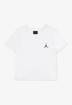 T-shirt blanc à manches courtes avec texture côtelée et petit logo Jumpman noir sur la poitrine gauche. Aucun élément d’arrière-plan visible.