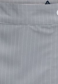 Tessuto grigio chiaro con sottili strisce verticali bianche, con una vita cucita e una texture liscia. Dettaglio del bottone bianco rotondo visibile.