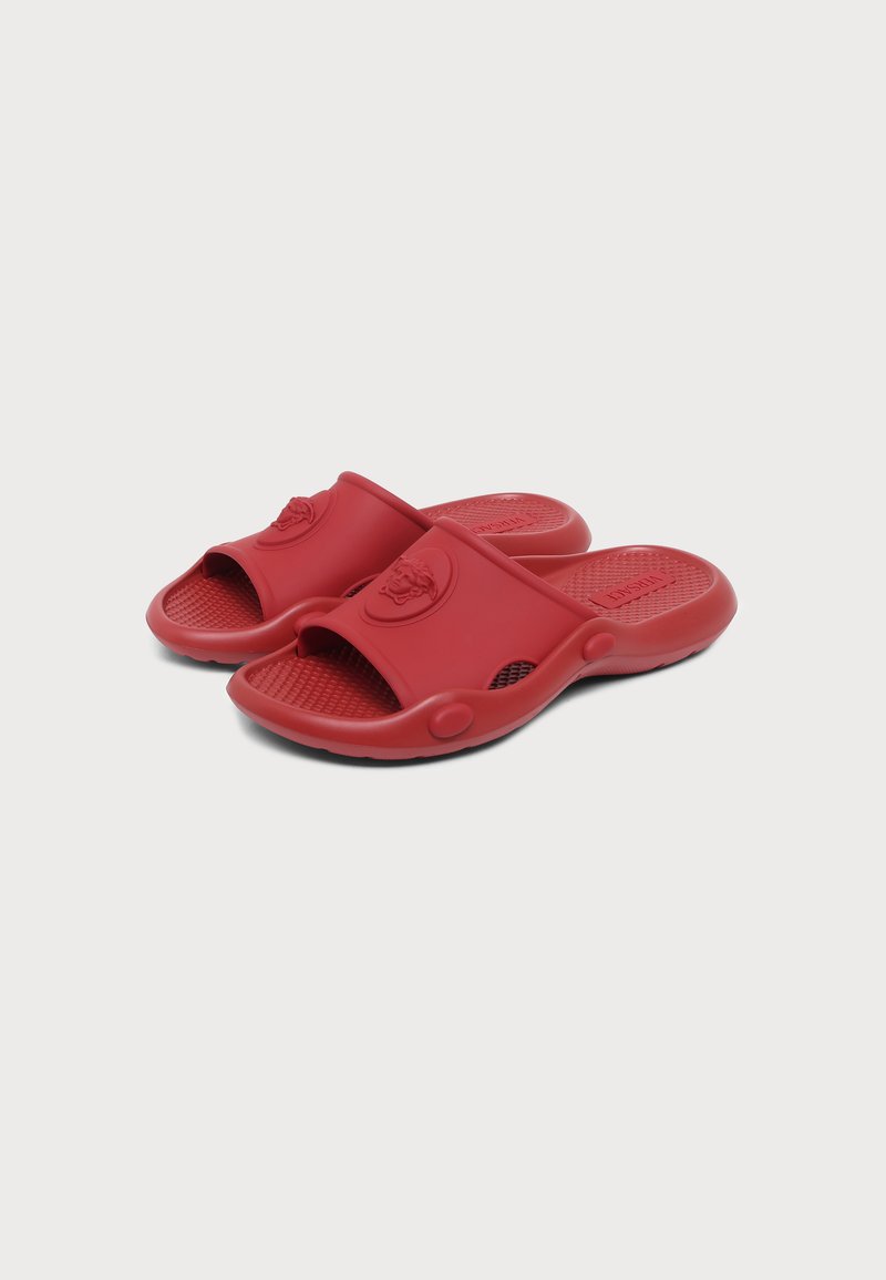 Paar rote Slip-On-Sandalen mit strukturierten Fußbetten und eingeprägtem Logo auf den breiten Frontriemen, für den lässigen Gebrauch entworfen.