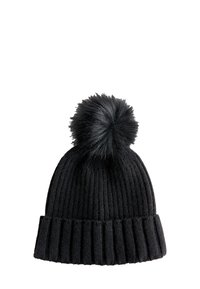Bonnet en tricot noir avec une texture côtelée et un grand pompon en fausse fourrure noire sur le dessus. Le bord est replié pour plus de style et de chaleur.
