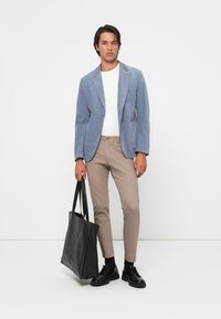 Light blue blazer, white t-shirt, beige slim-fit trousers, black leather tote bag, and black shoes. Smooth fabric and tailored fit.