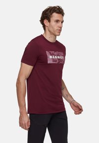 Czerwony t-shirt Mammut z krótkim rękawem, z jasnoszarym logo na prostokątnym wzorze, wykonany z miękkiej bawełny, w klasycznym kroju.