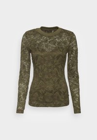 Olivgrön långärmad topp i spets med ett lövmönster; har rund halsringning och figurnära silhuett.