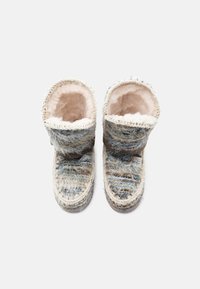 Zābaki ar mākslīgās kažokādas oderi, kuriem ir teksturēts daudzkrāsains apdare, brūns lentes akcentējums un kontrastējošas šuves, radīti ērtībai un siltumam.